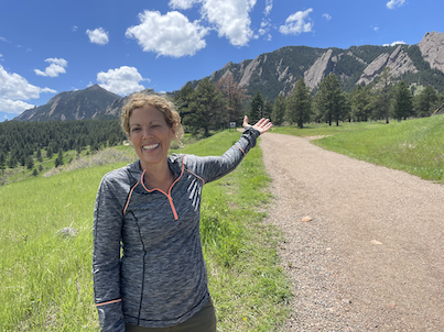 Tara Winer extending arm out to the mountains